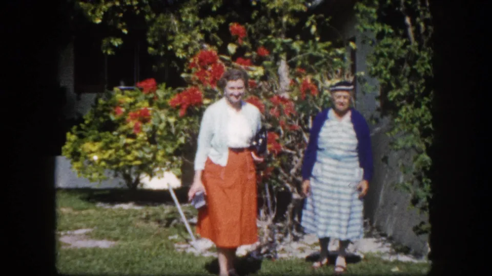 Two older women in a subtropical garden, Tampa Florida c. 1960: near-identical framing to preceding frame, a natural home-movie portrait pause.