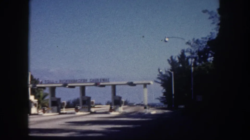 Rickenbacker Causeway toll plaza, Miami area, circa 1960, shot approaching the booth from a moving car on 8mm color film.