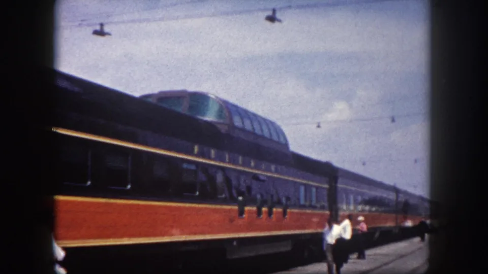 8mm home-movie frame showing passengers on a platform beside a dome-car passenger train at Tampa station, circa 1960.