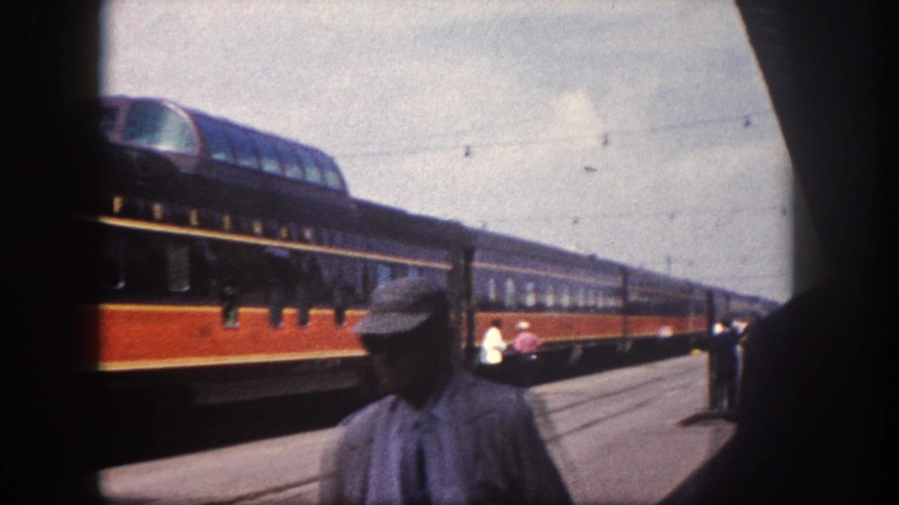 1960 Florida station: a platform figure in cap and work clothes in the foreground, City of Miami passenger train stretching behind him along the platform.