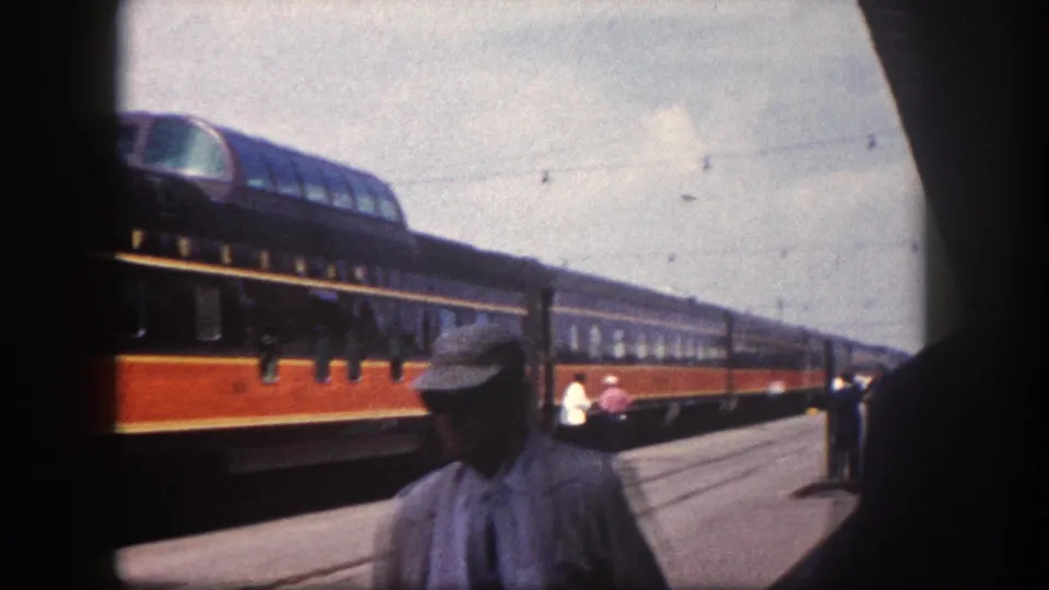 1960 Florida station: a platform figure in cap and work clothes in the foreground, City of Miami passenger train stretching behind him along the platform.