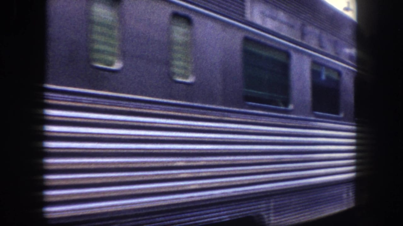 Detail of a dark blue ribbed streamliner passenger car exterior showing horizontal ribbing and windows, circa 1960, 8mm home movie