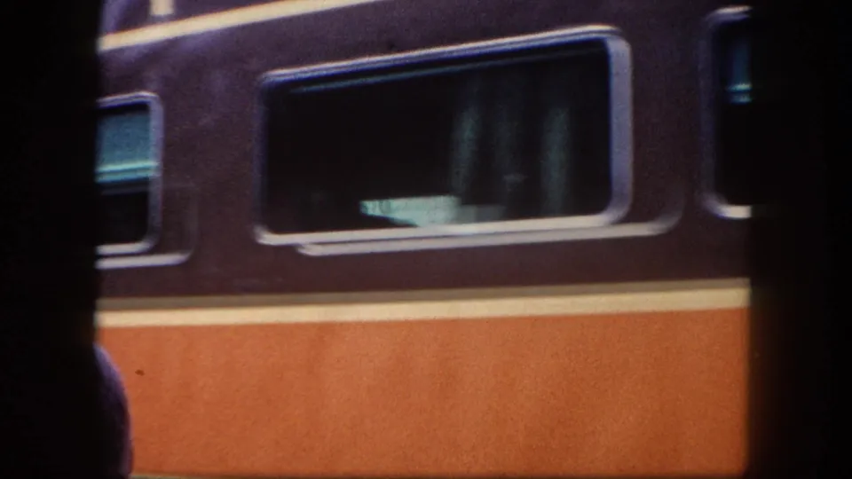 Passenger car in maroon and orange livery with large rectangular windows at a station platform, likely Tampa area, circa 1960, 8mm