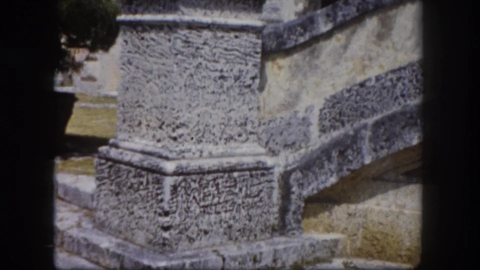 Tight close-up of a heavily textured stone plinth base with layered stone molding, Tampa Florida area estate, circa 1960 8mm footage.