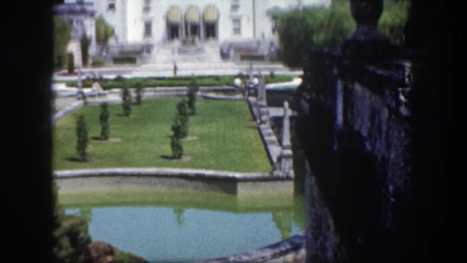White Italian Renaissance-style estate building with formal gardens, reflecting pools, and geometric topiary, Tampa, Florida, circa 1960.