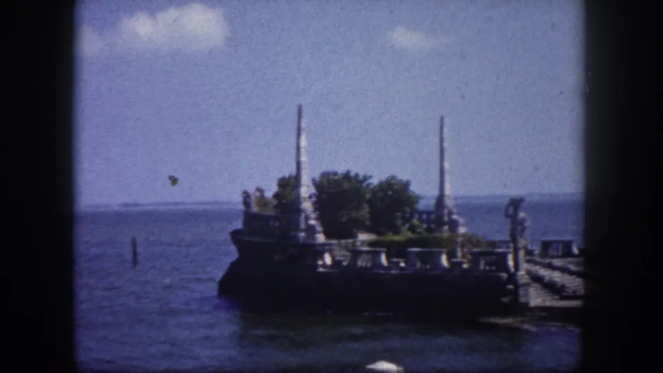 8mm home movie frame circa 1960 showing an ornate stone waterfront feature with decorative stonework and pier pilings in Tampa Bay area, Florida.