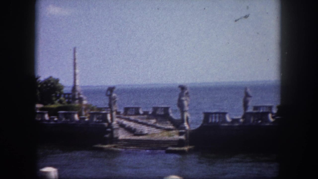Continued pan across ornate stone waterfront ruins with tall spires and carved statues, Florida, circa 1960, on 8mm film.