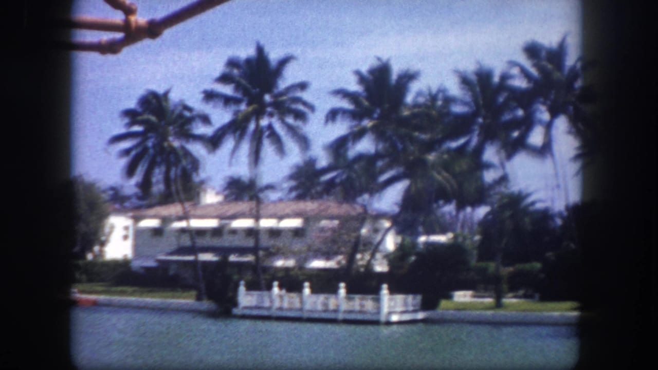 Waterfront estate with white stucco facade and dock structure across a Tampa-area canal, circa 1960, 8mm home movie from a passing boat.