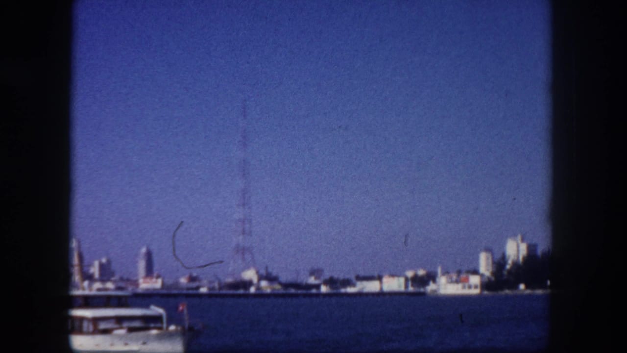 Tampa, Florida mid-century skyline viewed from Tampa Bay, circa 1960, with antenna tower at right and the bow of a white motorboat at lower right.