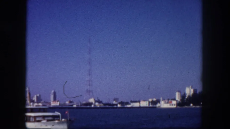 Tampa, Florida mid-century skyline viewed from Tampa Bay, circa 1960, with antenna tower at right and the bow of a white motorboat at lower right.