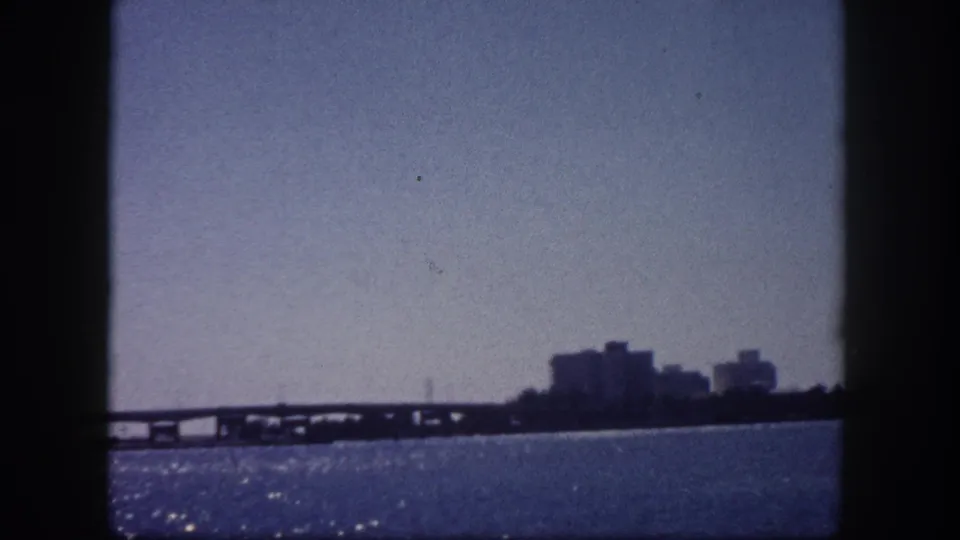 Wide Tampa Bay area view with a low causeway and distant urban skyline, circa 1960, filmed on 8mm home-movie film.