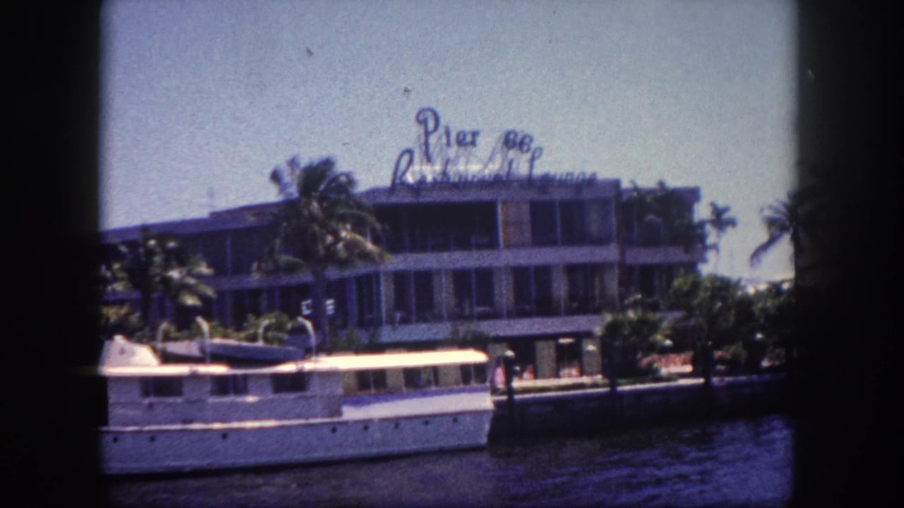 8mm film frame showing the Pier 88 Restaurant Lounge waterfront facade in what appears to be Tampa, Florida, circa 1960, with a large white vessel moored alongside.