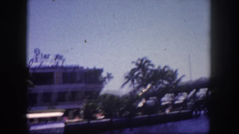 8mm film frame from what appears to be Tampa, Florida, circa 1960; camera panned further right so palm trees largely obscure the Pier 88 Restaurant Lounge building.