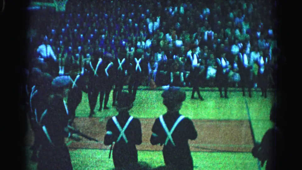 1963 Hagerstown, Maryland: wider angle showing multiple rows of uniformed marchers with white X-cross-straps; spectator stands packed across the full upper background.