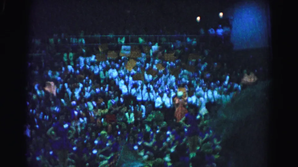 Crowd filling stadium stands at a nighttime sporting event, Hagerstown, Maryland, circa 1963; signs and raised arms visible throughout.