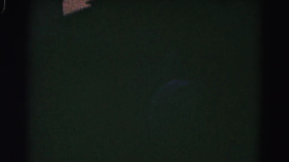 Low-light final frame showing a dark residential silhouette with only a faint roof edge and small twilight sky area visible.