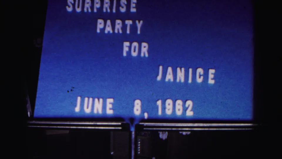 Early-1960s 8mm frame showing a blue title card announcing a surprise party for Janice dated June 8, 1962.
