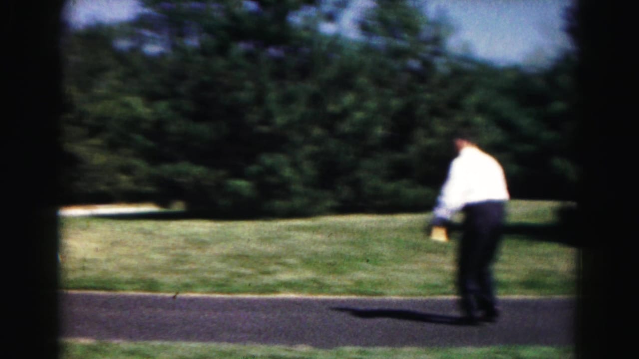 A man in a white shirt runs or steps across the driveway during the 1963 outdoor yard game in Hagerstown.