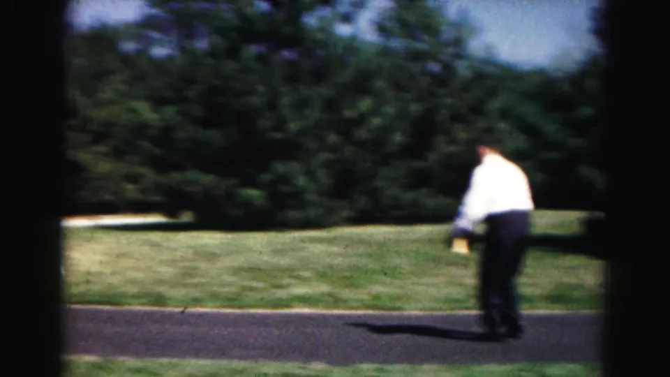 A man in a white shirt runs or steps across the driveway during the 1963 outdoor yard game in Hagerstown.