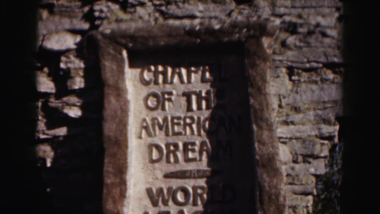 Close view of a stone plaque set into a rough wall with partially readable engraved text.