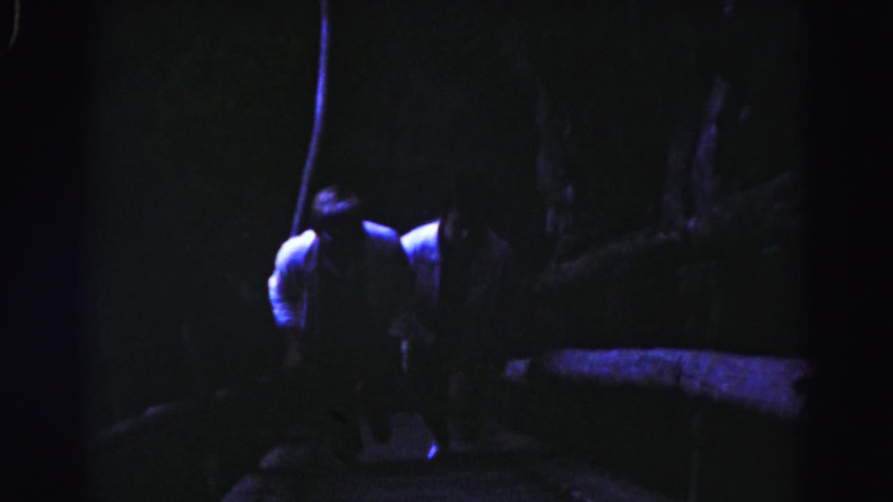 Blue-tinted 1963 home-movie frame from Hagerstown showing a person on a narrow, shadowed stairway.