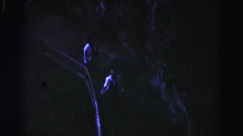 In 1963 Hagerstown home-movie footage, a man in a light shirt appears partway up a shadowed outdoor staircase at night.