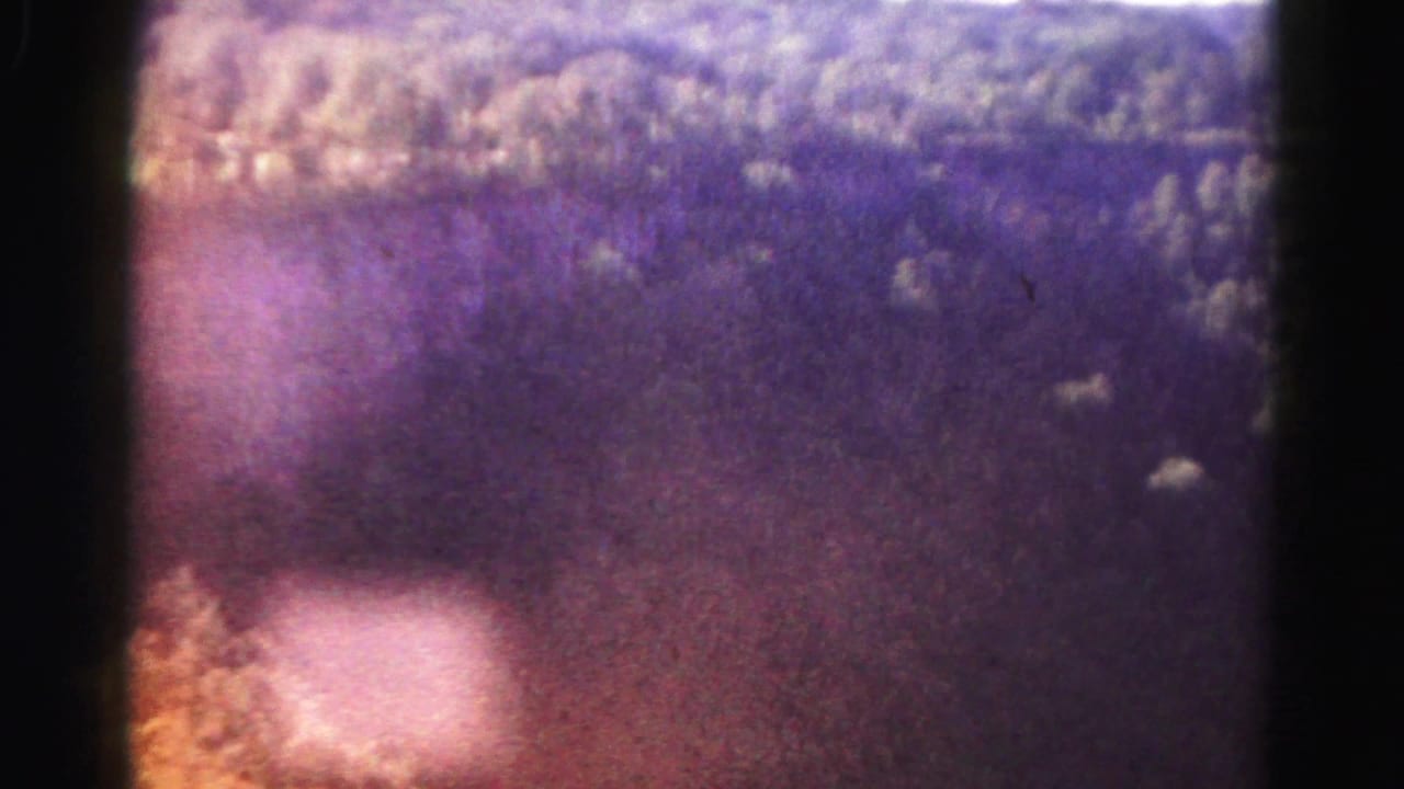 Aerial 8mm view of forested mountain terrain near Hagerstown metadata, tinted purple with a small bright area below.