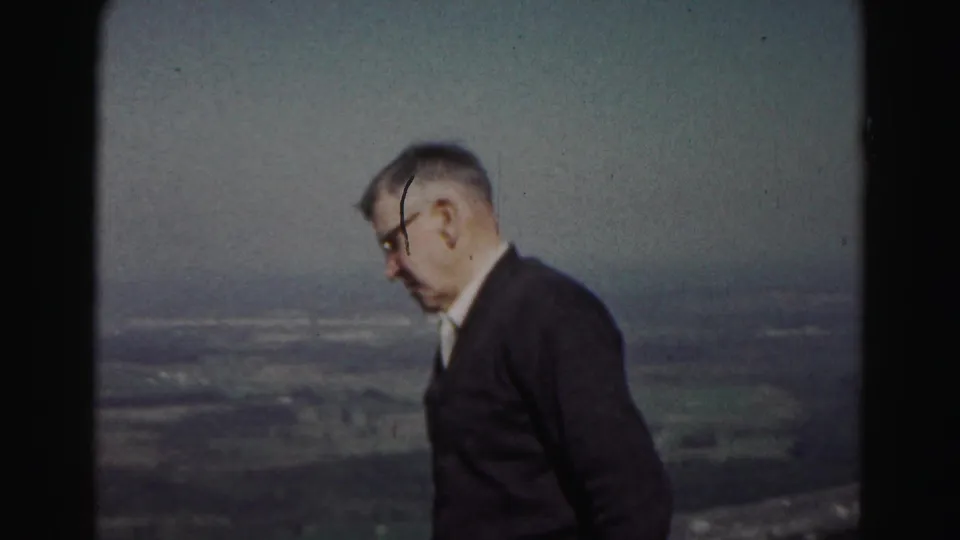 1963 8mm frame of an older man in profile walking along a hilltop above the Hagerstown-area valley.