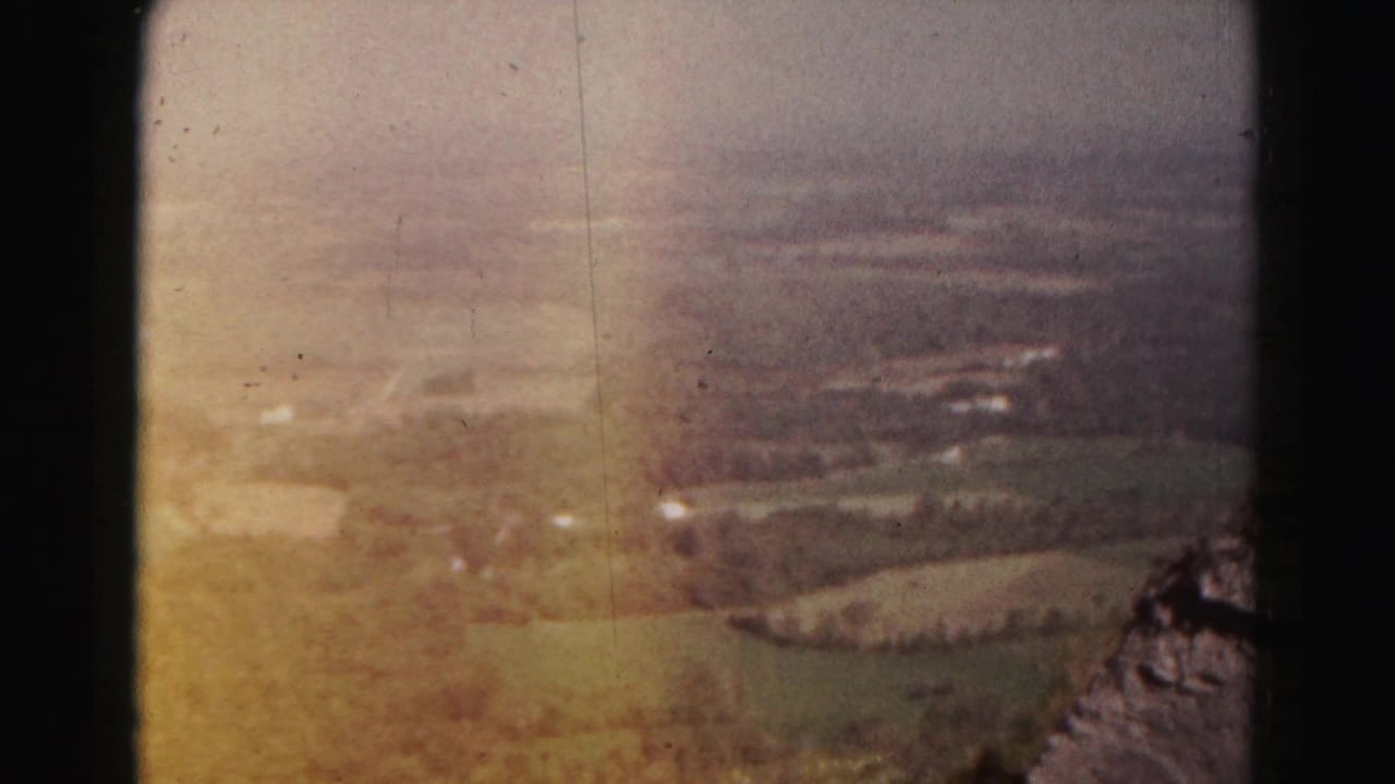 1963 8mm view near Hagerstown, Maryland, looking from a mountain edge across a hazy rural valley and patchwork fields.