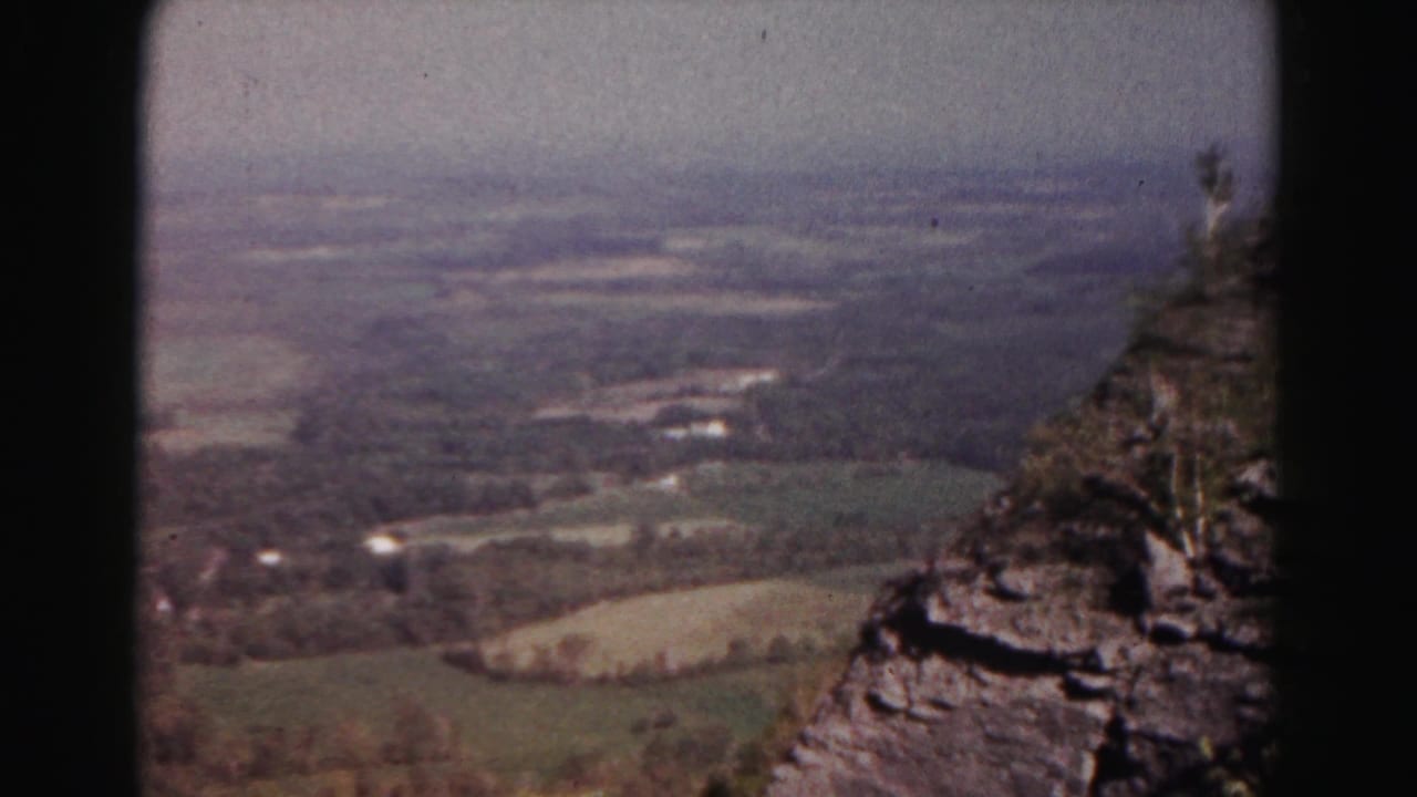 Mountain-overlook frame from the 1963 Hagerstown, Maryland footage, with rock ledges at right and a rural valley below.