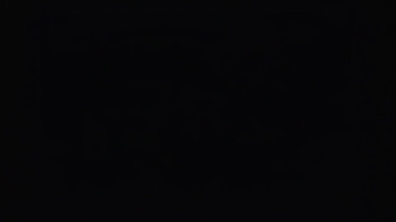 Mostly dark film frame with only a faint landscape area visible near the lower edge.