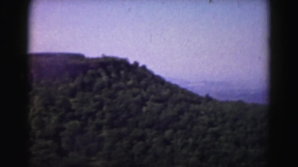 1963 8mm view near Hagerstown, Maryland, showing a wooded ridge and hazy distant horizon.