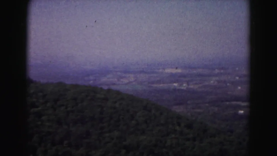 A 1963 home-movie view near Hagerstown shows a forested foreground dropping toward a hazy valley.