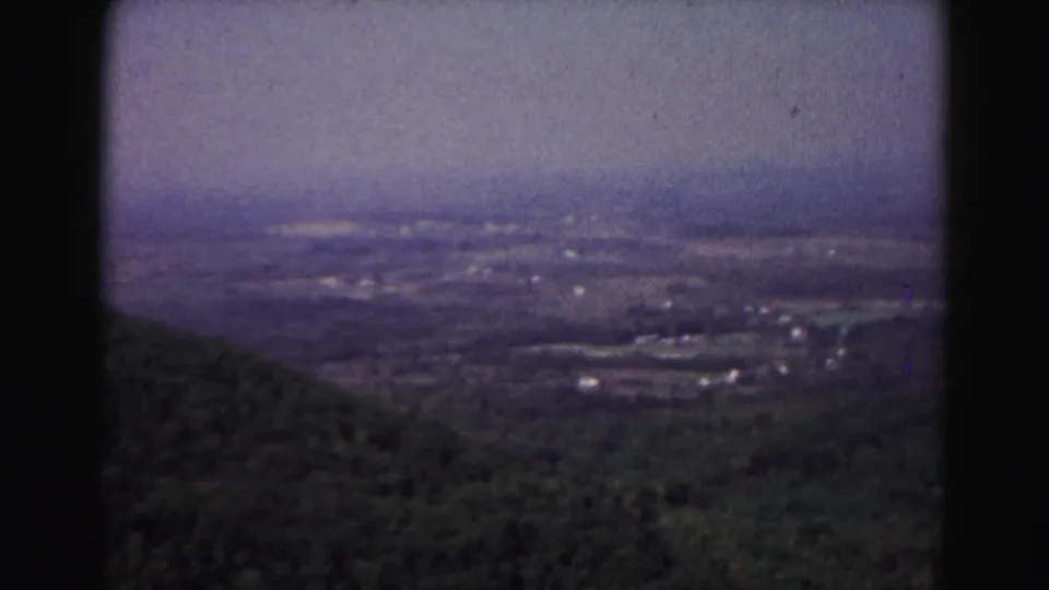 1963 8mm landscape near Hagerstown, Maryland, looking over trees toward scattered rural structures in haze.