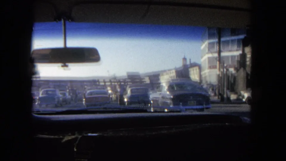 Final driving frame shows dense street traffic in the stated 1962 Tijuana setting, seen through the car windshield.