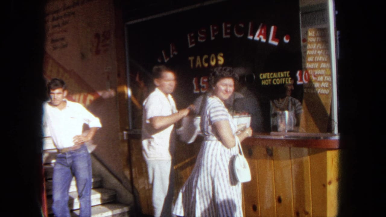 Woman turns near the taco stand counter while two men stand by the window and steps.