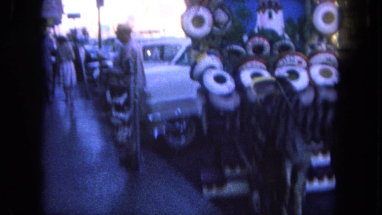 Blurred curbside display with circular painted shapes, pedestrians, and parked cars.