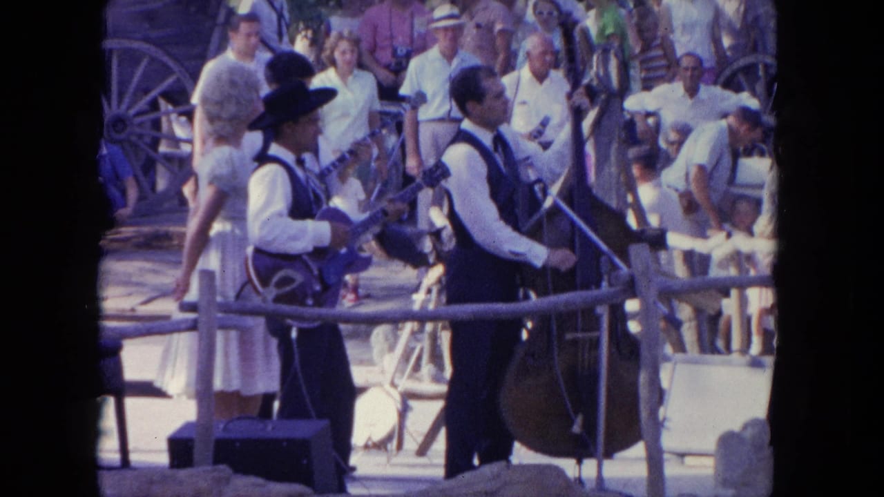 The Tijuana outdoor stage view shows the guitarist, upright bass player, nearby woman, and spectators in bright daylight.