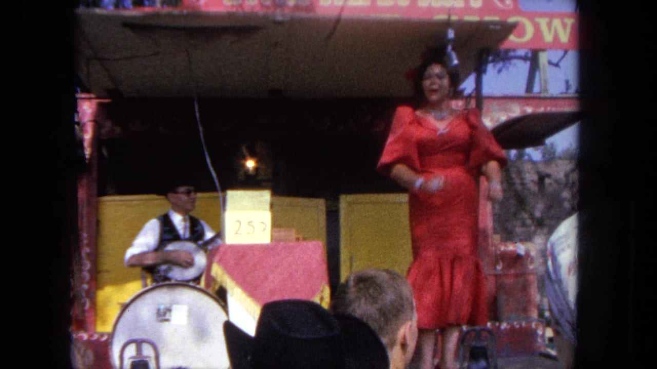The singer faces the audience on the 1962 Tijuana carnival stage, with a 25-cent placard and banjo player visible nearby.