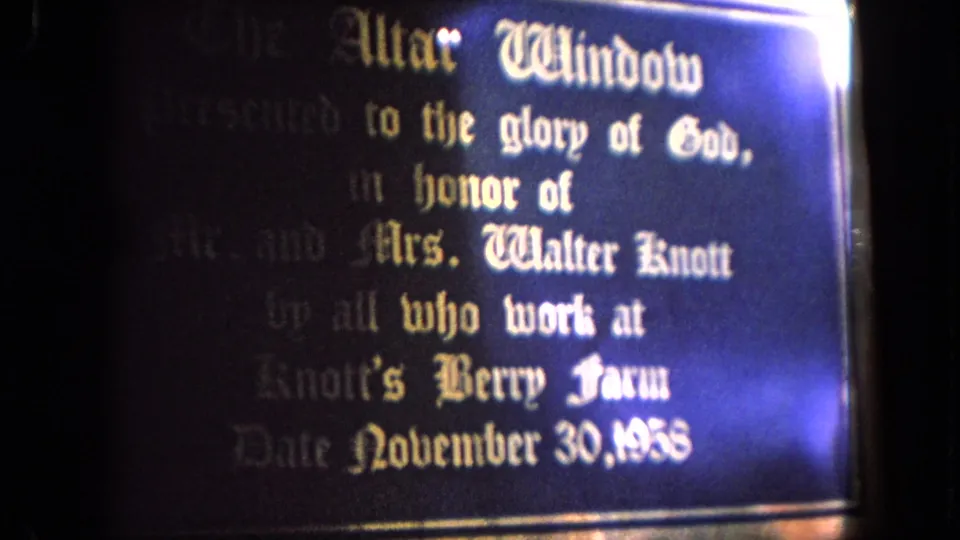 The camera moves closer to the altar-window dedication plaque, where the Knott family and Knott's Berry Farm reference are partly legible.