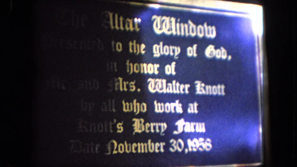 Final close-up of the altar-window plaque in 1962 Tijuana footage, showing memorial wording and a strong blue-white light flare.
