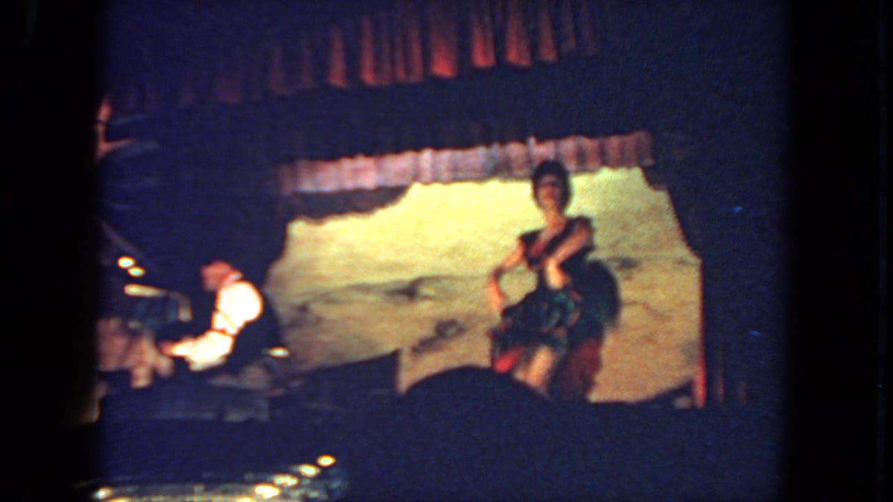 Female dancer on stage near a seated pianist at a piano.