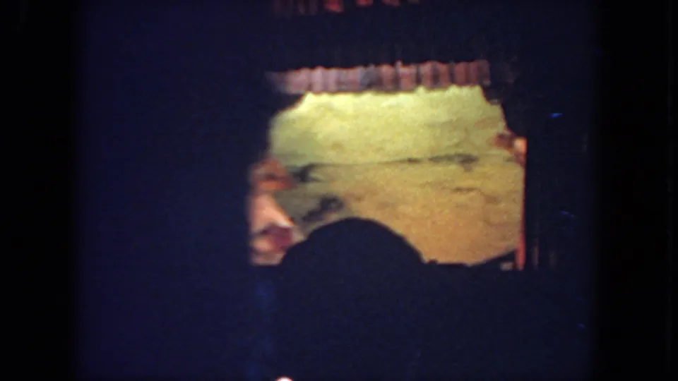 During the brief performance, the dancer passes partly out of frame, emphasizing the handheld audience viewpoint of the 8mm recording.
