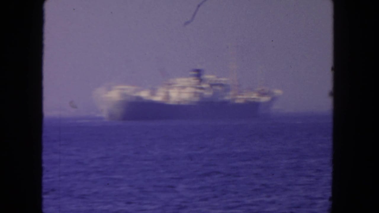 Soft 8mm view of a large steamer moving across the ocean off San Diego in 1962.