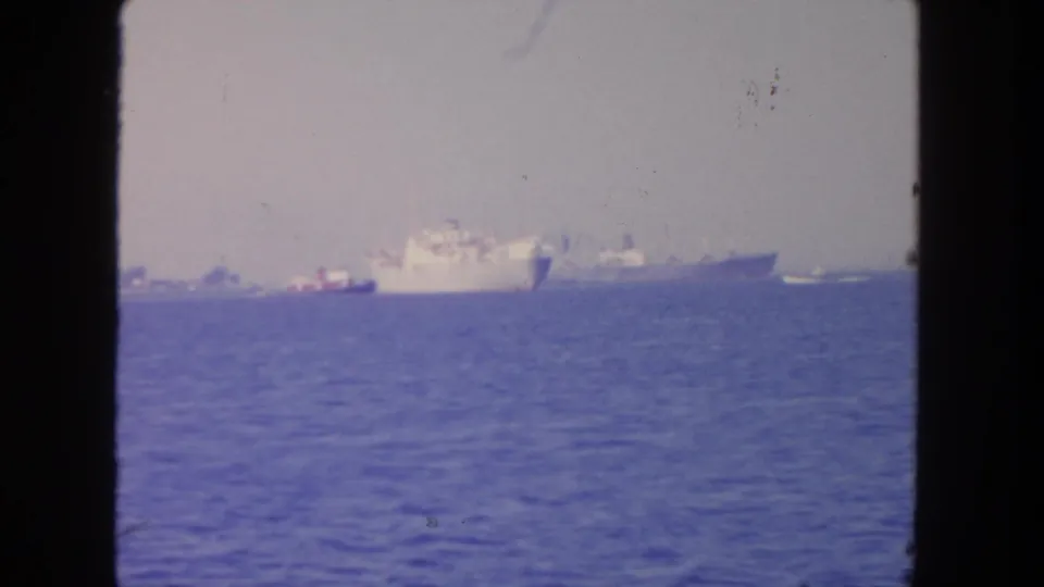 Distant naval or support vessels appear offshore near San Diego in this 1962 8mm home-movie frame.