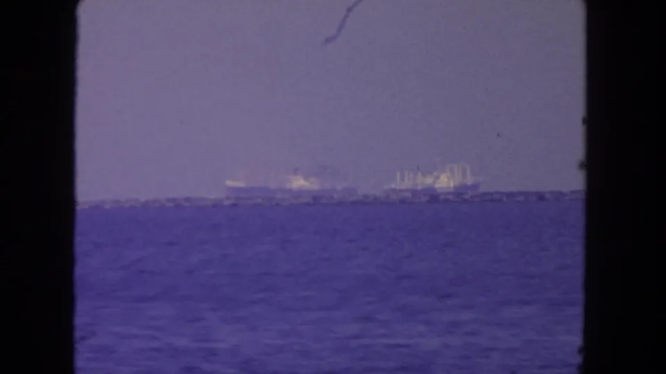 Hazy 8mm view of ships off San Diego, with open water filling the foreground and vessels near the horizon.
