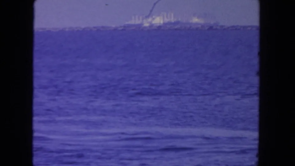 1962 San Diego 8mm frame showing a distant large ship across open water under a hazy sky, with visible film gate borders.