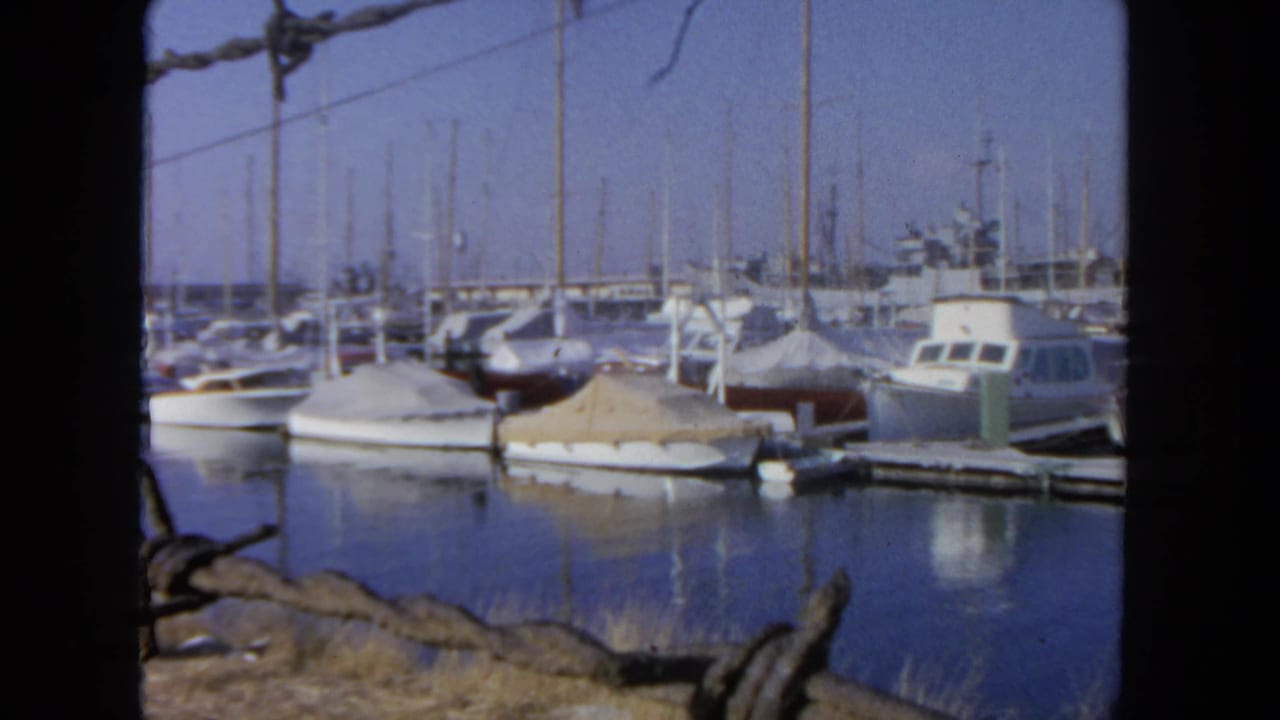 San Diego marina view from 1962 showing docked boats, tall masts and still water under a clear sky.