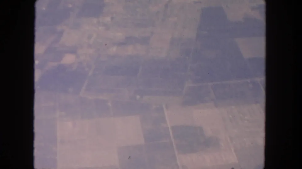 Faded 1962 aerial view of rural San Diego-area fields and roads framed by dark window or film edges.