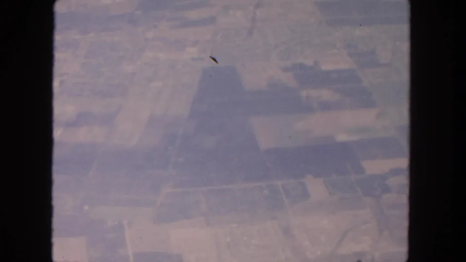 San Diego-area 1962 airplane-window view of rural plots and dirt roads with visible 8mm frame artifacts.